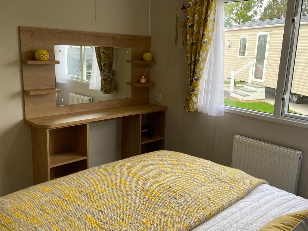 a bedroom with a bed and a desk and a window at Hutchinson's Willerby Kelston with Hot tub in Cottam