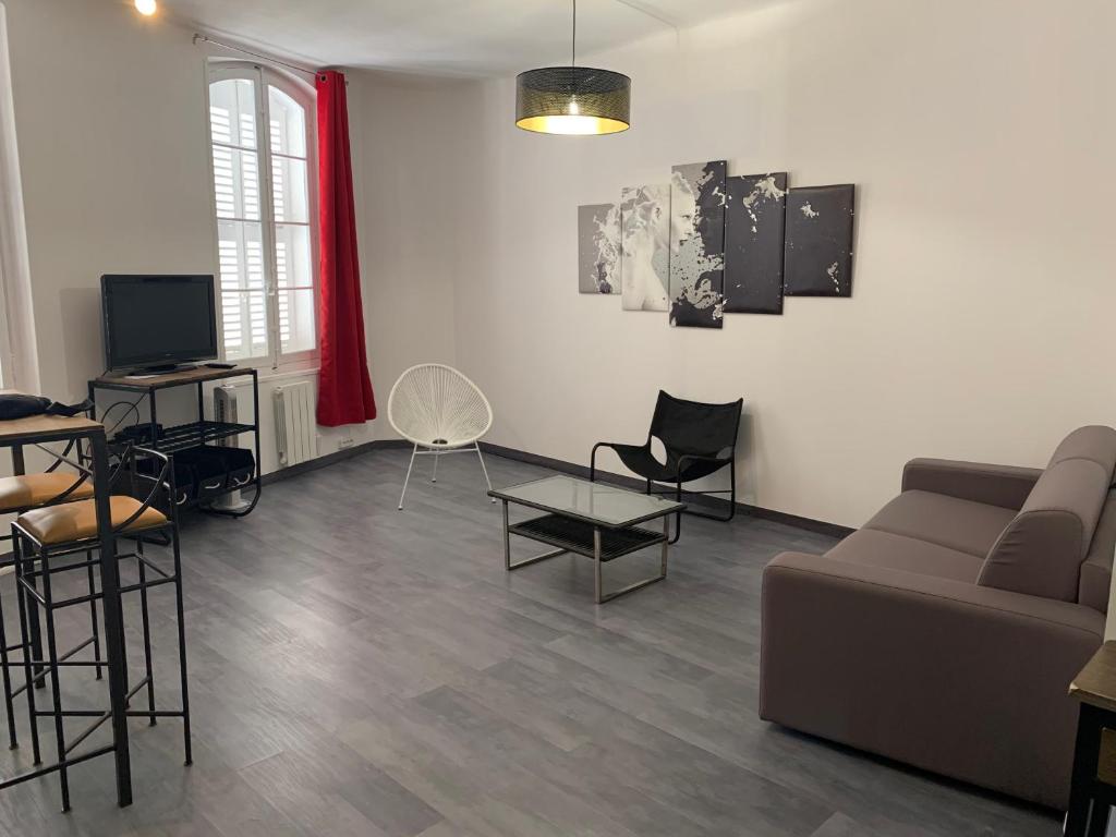 uma sala de estar com um sofá, uma mesa e cadeiras em T2 - Quartier mythique du panier em Marselha