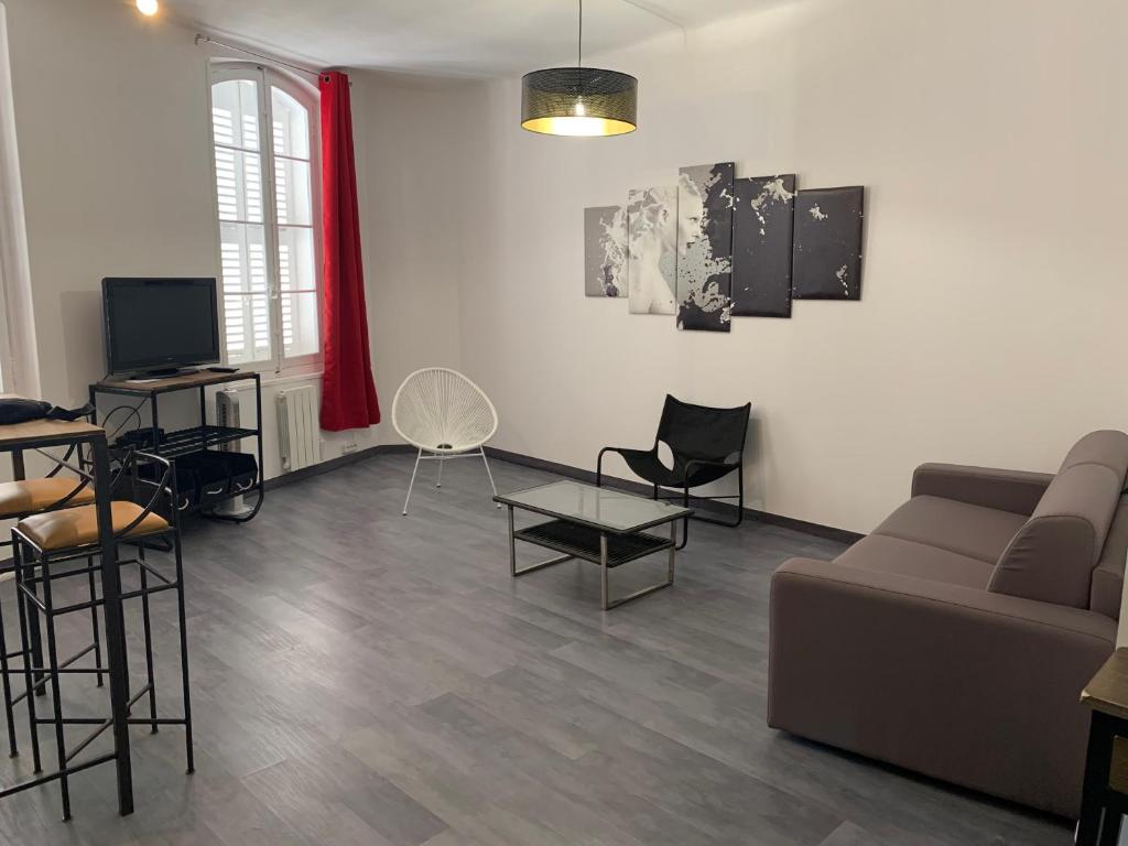 un salon avec un canapé, une table et des chaises dans l'établissement T2 - Quartier mythique du panier, à Marseille