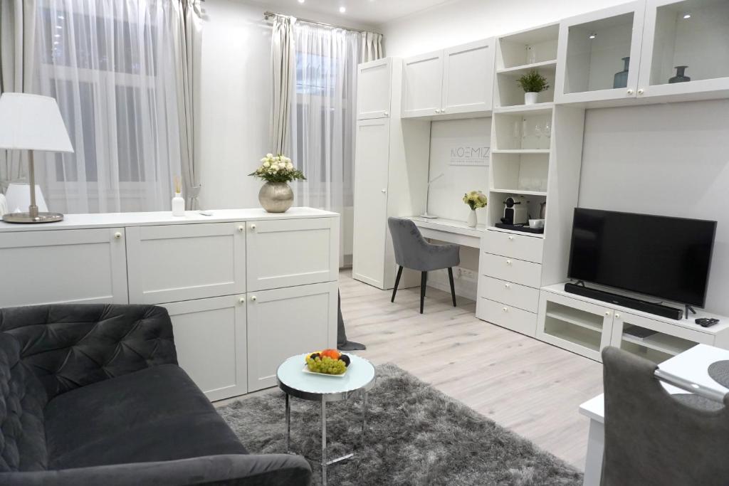 een woonkamer met een bank en een tv bij Noemiz Exclusive Apartments in Boedapest