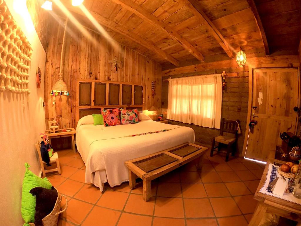 um quarto com uma cama grande num quarto de madeira em Zoyatl - Xamikal em Zacatlán