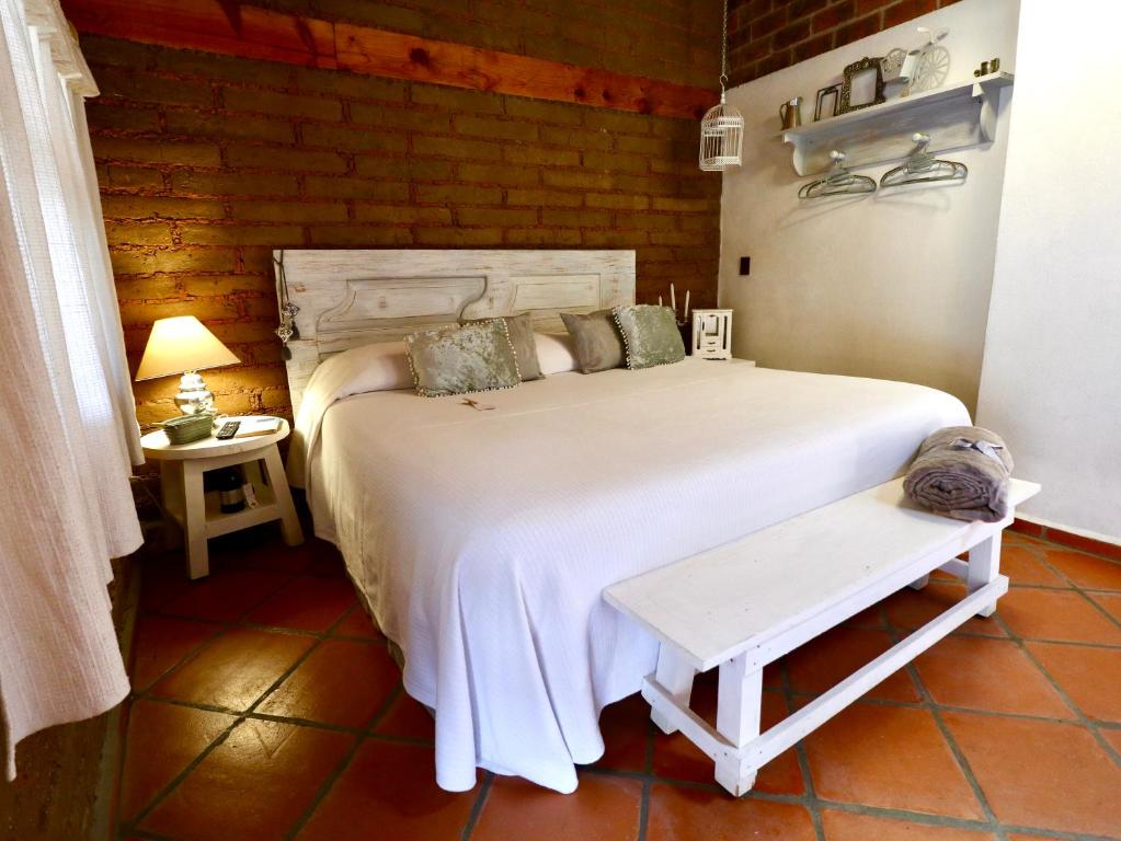 Un dormitorio con una gran cama blanca y una mesa en Iztak - Xamikal, en Zacatlán