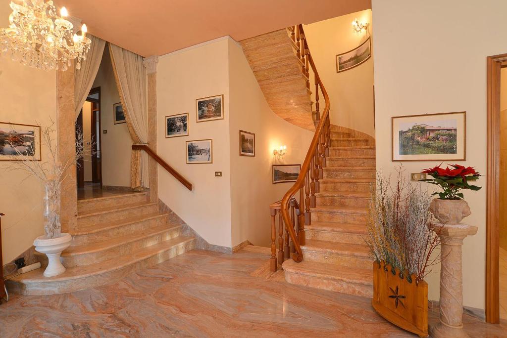 uma escadaria numa casa com pisos de madeira e um lustre em B&B Villa Adriano em Cavaion Veronese