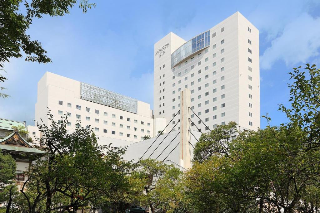 um grande edifício branco com árvores em frente em Hotel Fujita Fukui em Fukui