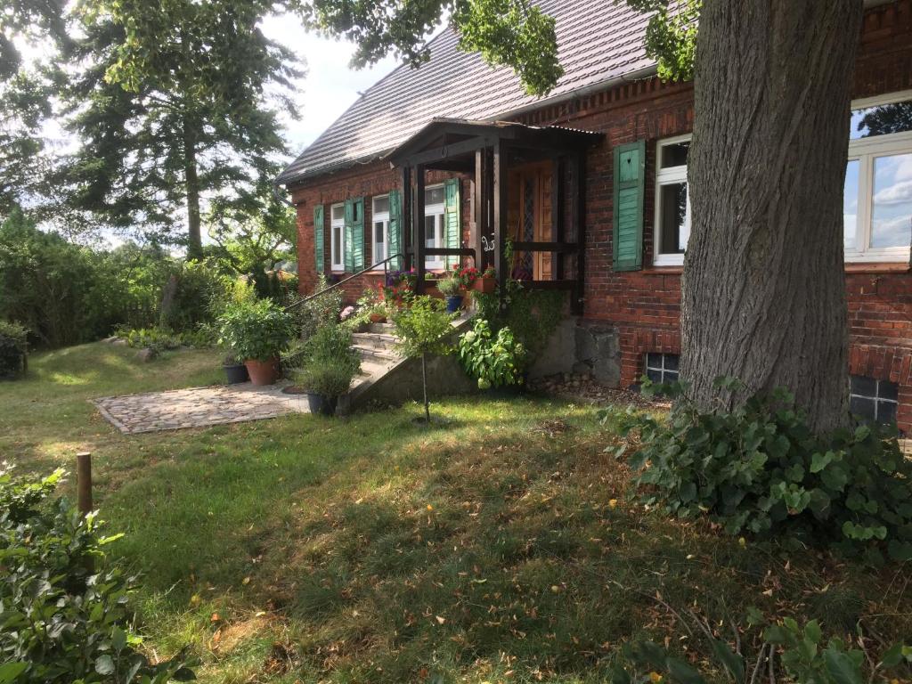 una casa in mattoni con portico e albero di Zum Schwalbennest a Wredenhagen