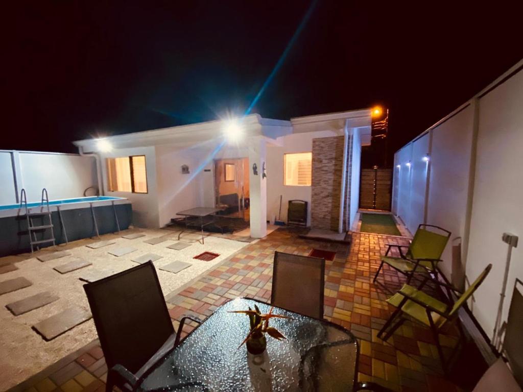 - une vue sur le patio la nuit doté d'une table et de chaises dans l'établissement Casa playa herradura #1, à Herradura