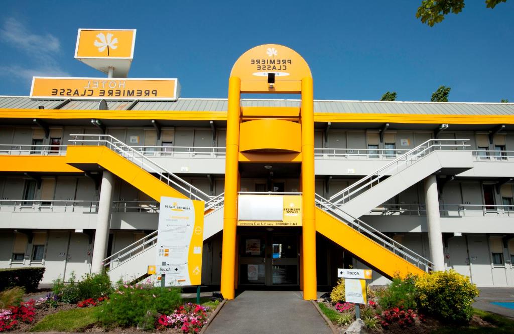 a hotel with a yellow stairwell in front of a building at Premiere Classe Bordeaux Est Lormont in Lormont