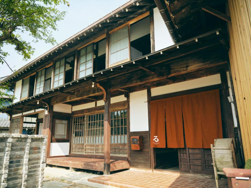 身延町にあるKominkayado LOOF Shonoieの木製のドアと窓のある古い建物