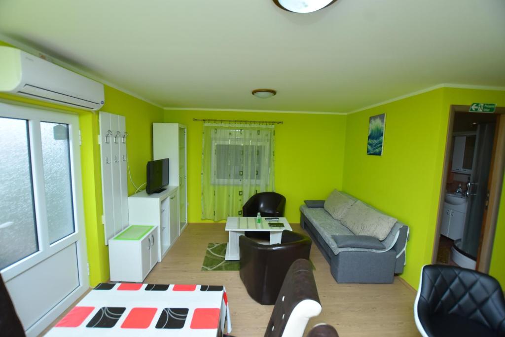a living room with green walls and a couch at Apartman Stevanovic in Kladovo