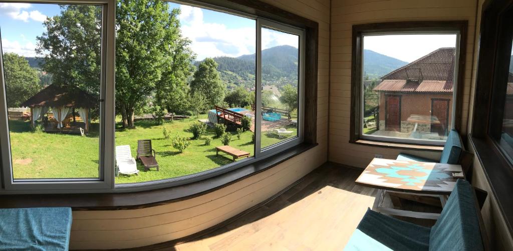 een kamer met 2 ramen en uitzicht op een tuin bij fazenda slavsko in Slavske