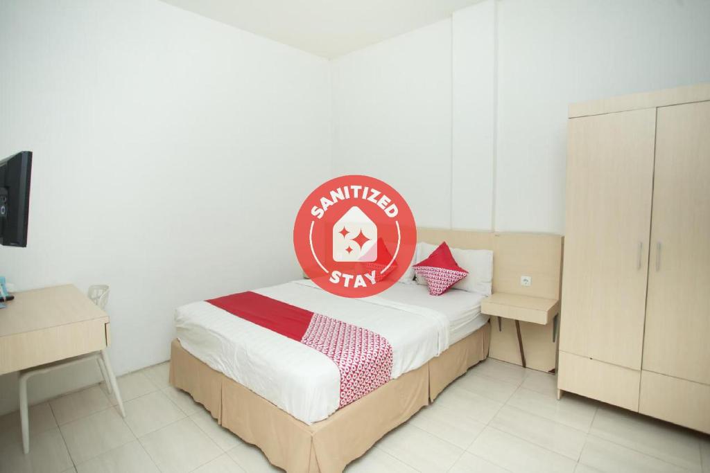 Una habitación con una cama con un cartel. en SUPER OYO 850 Lapan Lapan en Banjarmasin