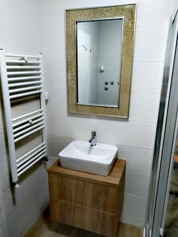 a bathroom with a sink and a mirror at CITY RENT 7 Apartments in Jagodina