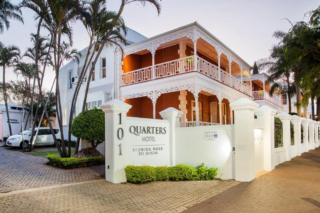 
a large white building with a clock on the front of it at Quarters Hotel in Durban
