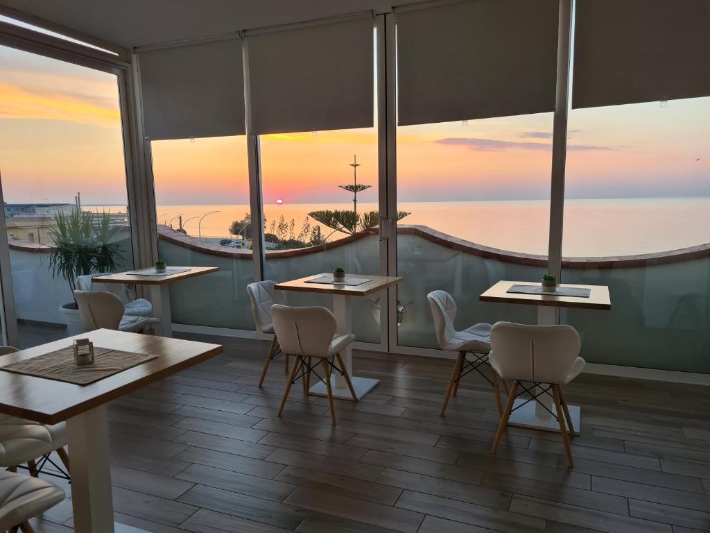 a dining room table with a balcony overlooking the ocean at Pantanello Rooms Avola in Avola