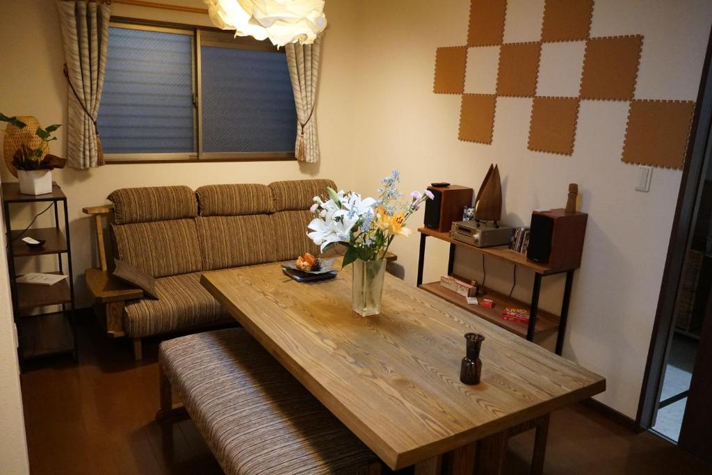 ein Wohnzimmer mit einem Tisch und einem Sofa in der Unterkunft Auberge du Tanuki Noir Maison d'Hôtes in Osaka