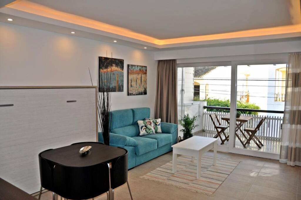 a living room with a blue couch and a table at Apartamento cerca de Puerto Banús y la playa in Marbella