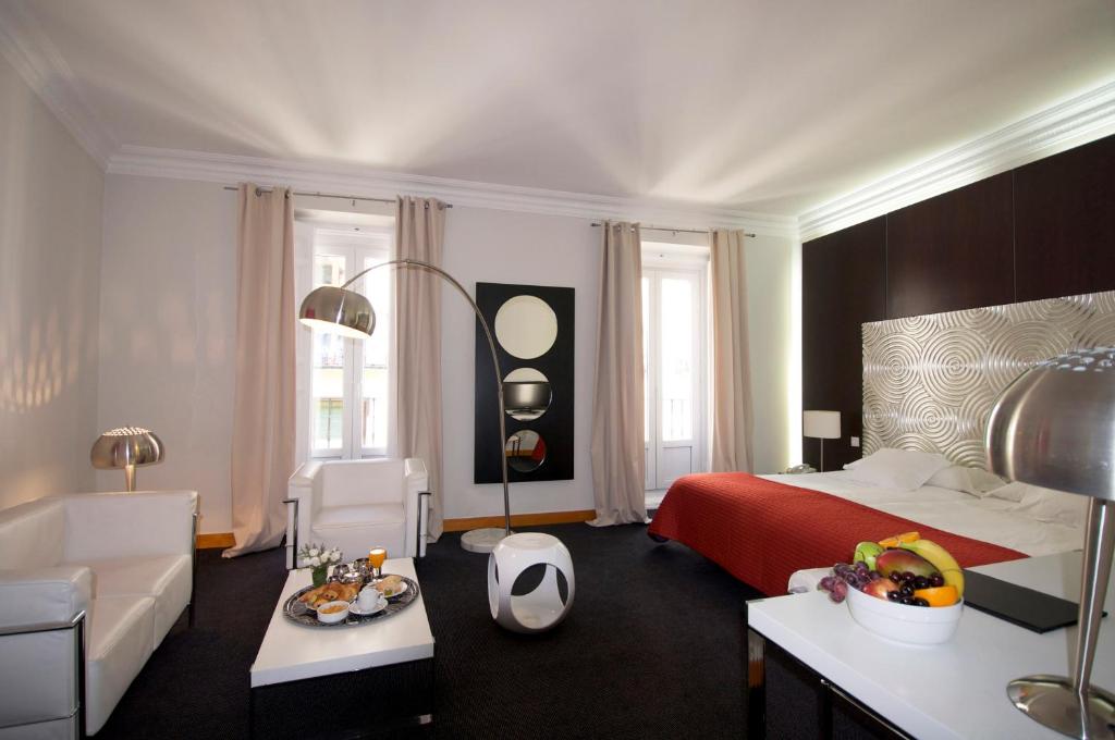 1 dormitorio con cama, sofá y mesa en Suite Prado, en Madrid