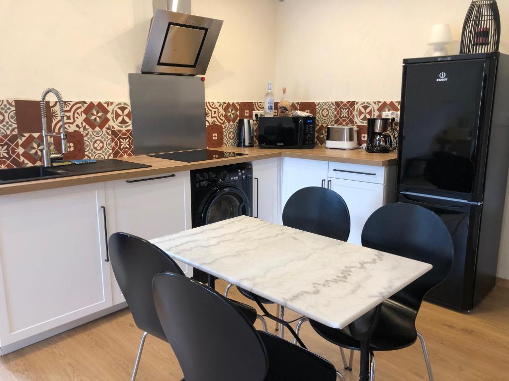 a kitchen with a table and chairs and a microwave at Maison au centre d&#39;un village typique in Omessa