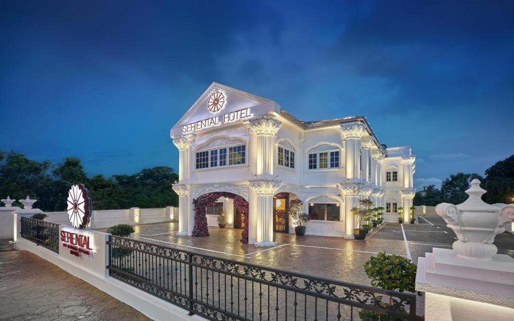 un grand bâtiment blanc avec une clôture devant lui dans l'établissement Seriental Hotel, à Tanjong Tokong