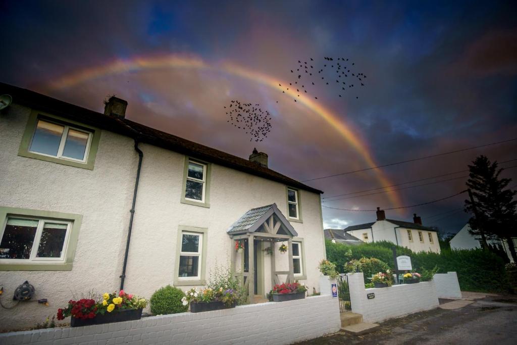 Un arcobaleno nel cielo sopra una casa di Midtown Farm Bed & Breakfast a Easton