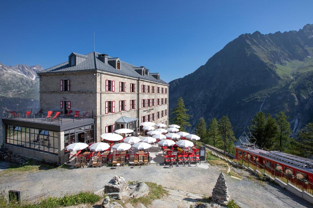 a building with a bunch of tables and umbrellas at Refuge du Montenvers in Chamonix-Mont-Blanc