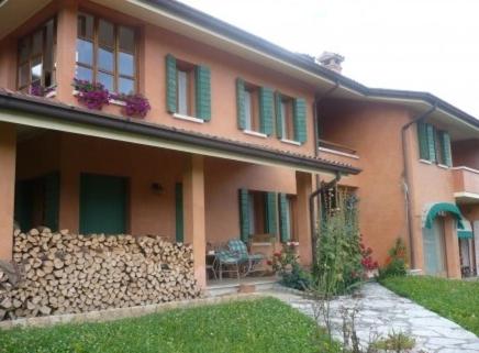 ein Haus mit grünen Fensterläden und einem Zaun in der Unterkunft B&B Relax in Miane