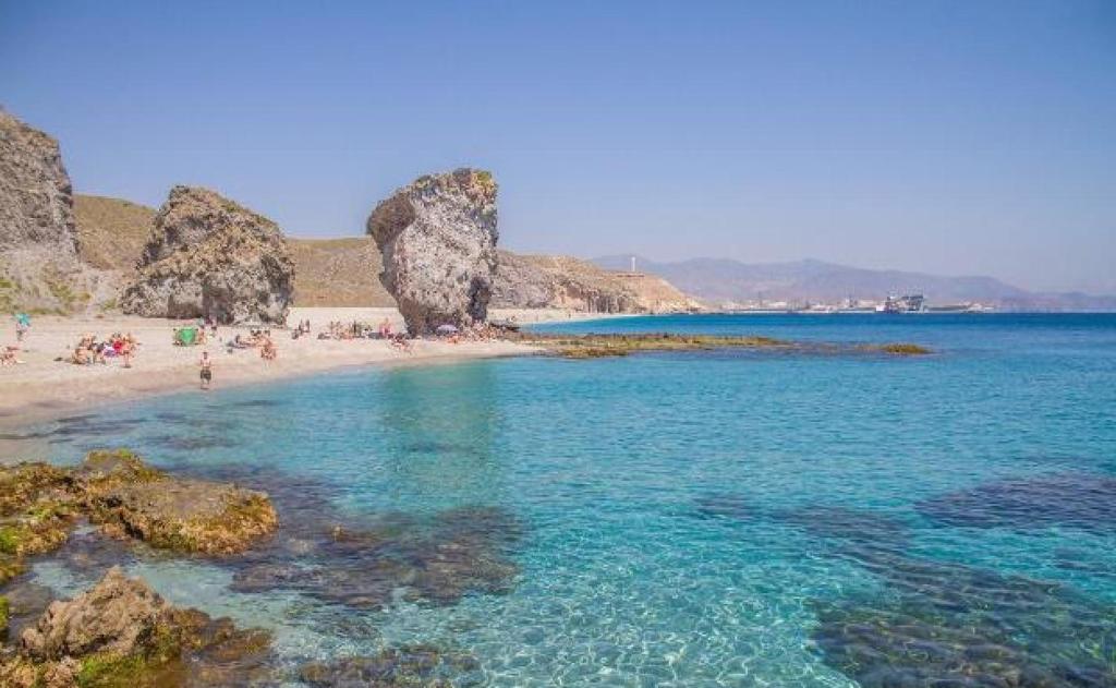 a beach with a bunch of people and rocks at Hotel Balisa in Níjar