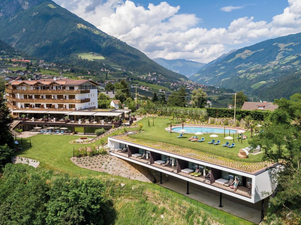 an aerial view of a resort with a swimming pool and mountains at Hotel Traubenheim in Tirolo