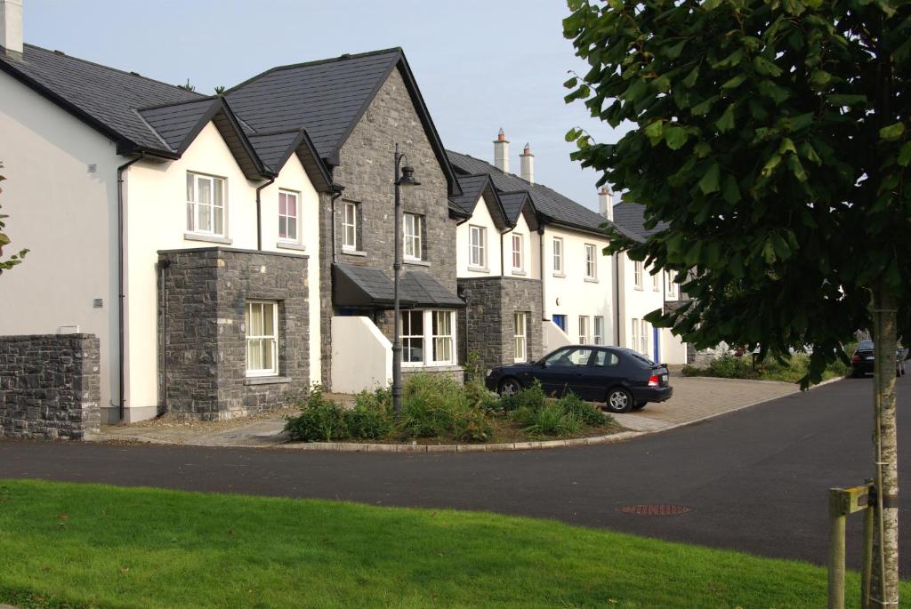 eine Reihe von Häusern mit einem Auto in der Einfahrt in der Unterkunft Bunratty Holiday Homes in Bunratty