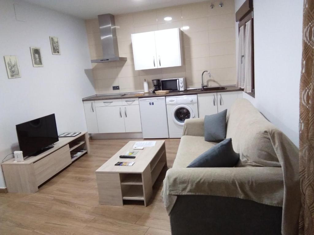 a living room with a couch and a kitchen at Puerta del Vado Bajo in Toledo