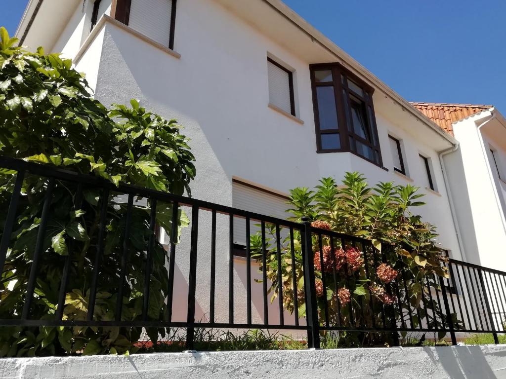 a black fence in front of a white house at Casa Airiños do monte in Cangas de Morrazo
