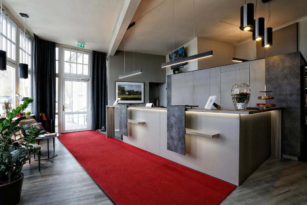 una cucina con tappeto rosso e tappeto rosso di Konsumhotel Dorotheenhof Weimar a Weimar