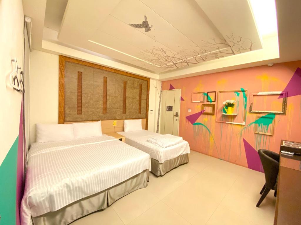 a bedroom with two beds and a colorful wall at Dong Men Hotel in Taipei