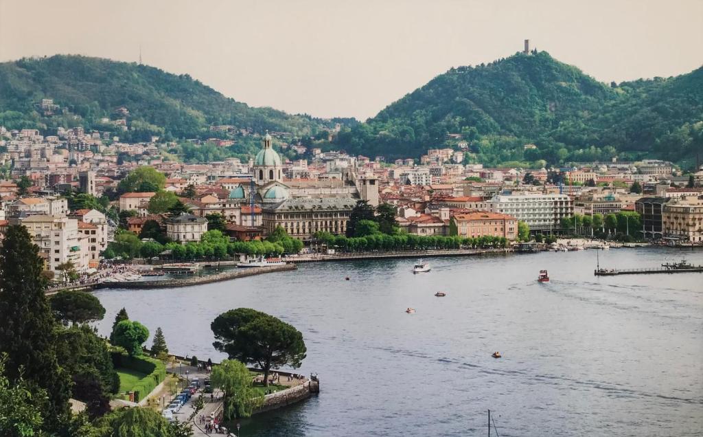 Blick auf einen Fluss mit einer Stadt im Hintergrund in der Unterkunft La Terrazza di Como in Como