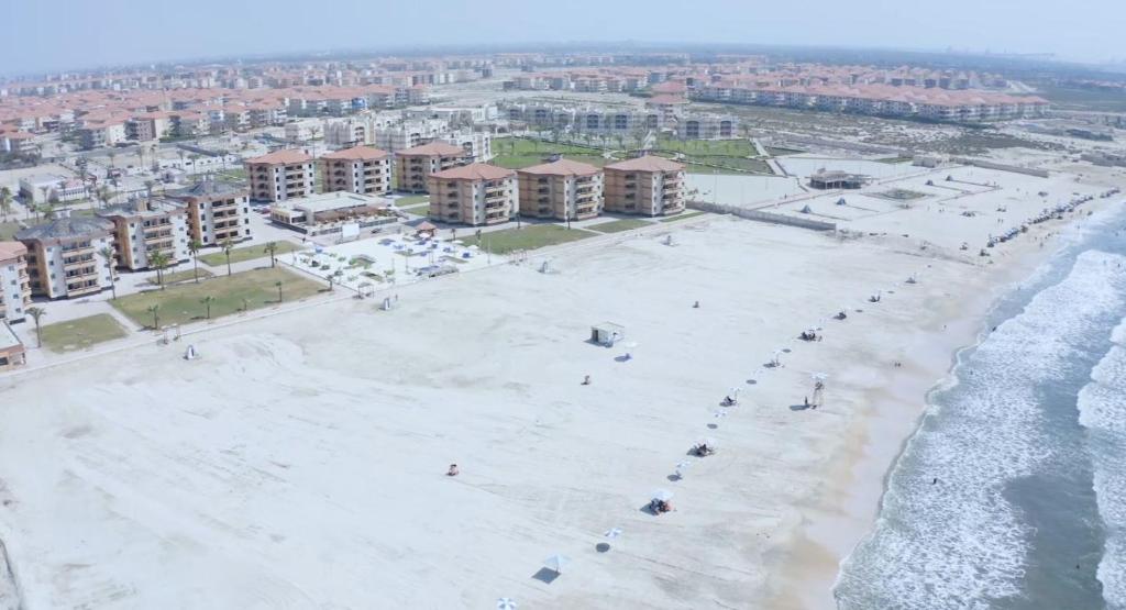 een luchtzicht op een strand met gebouwen en de oceaan bij Ras El Bar Apartments Armed Forces in Ras El Bar