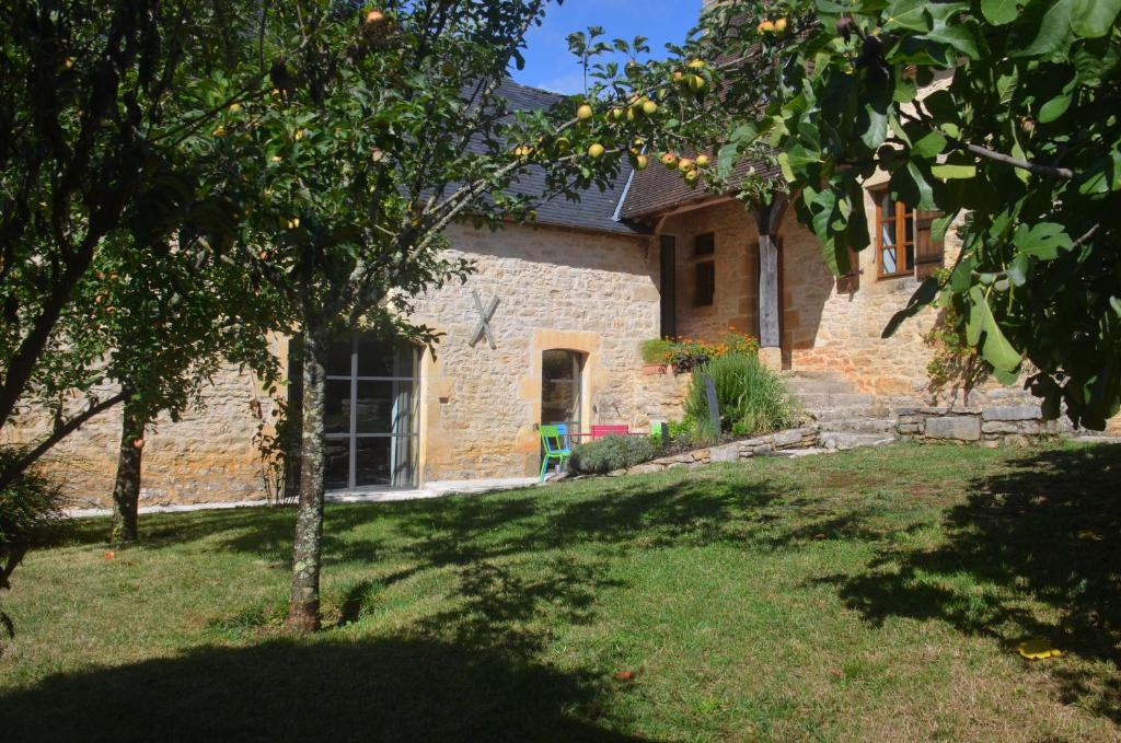 una casa in mattoni con un albero nel cortile di L'ère du temps a Cuzance