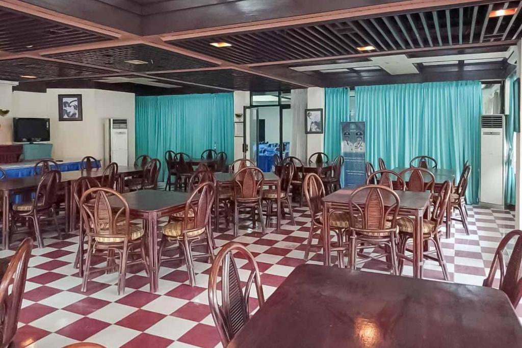 una sala da pranzo con tavoli e sedie di RedDoorz Plus near Tugu Mercusuar Anyer a Serang