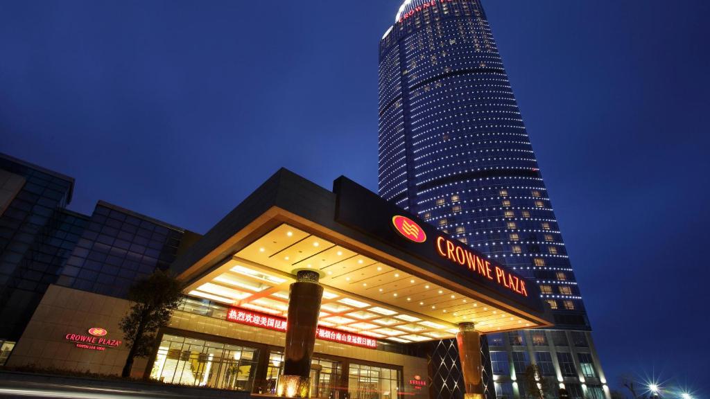 un bâtiment avec un haut gratte-ciel en arrière-plan dans l'établissement Crowne Plaza Yantai Sea View, an IHG Hotel, à Yantai