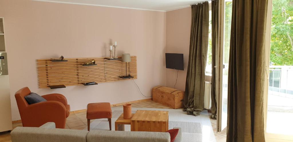ein Wohnzimmer mit einem Sofa und einem Tisch in der Unterkunft Bacchus - helles und geräumiges Appartement am Rande von Mainz in Mainz