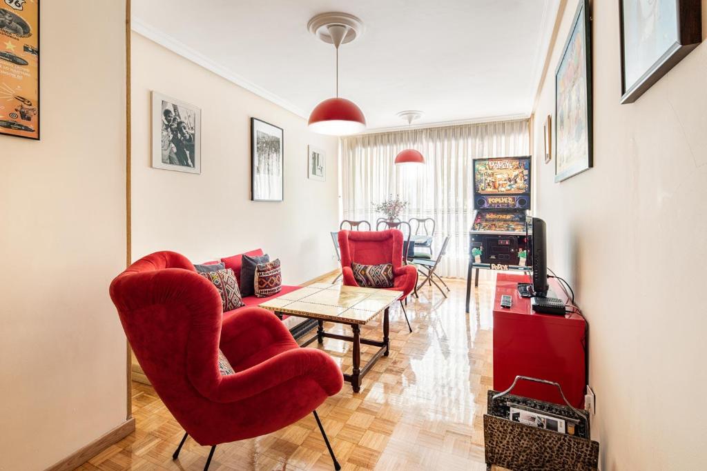 salon z czerwonymi krzesłami i stołem w obiekcie Magnifico apartamento en el centro de Oviedo w mieście Oviedo