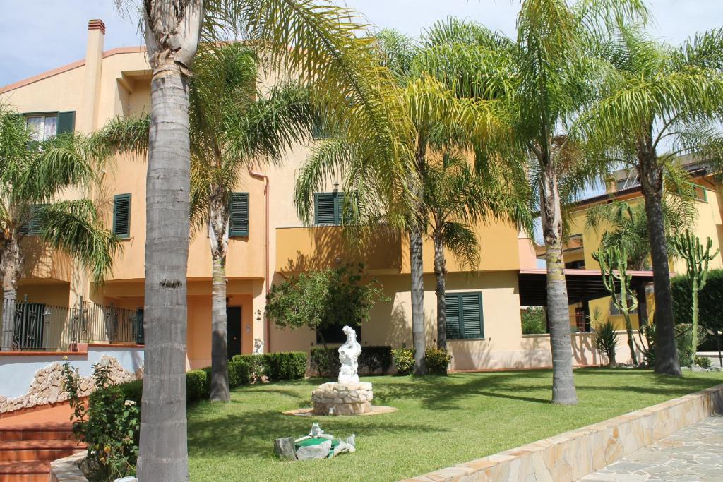 un edificio con palmeras y una fuente en Villa Terry, en Catona
