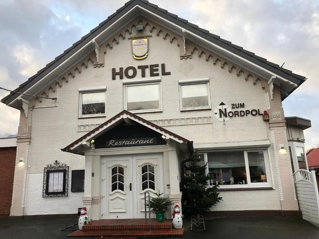 een groot wit gebouw met een hotelbord erop bij Hotel zum Nordpol in Schenefeld