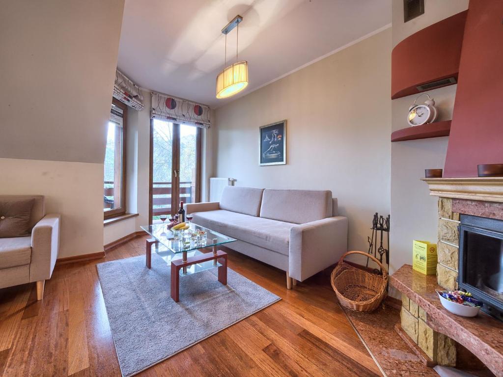 sala de estar con sofá y chimenea en VisitZakopane - Amber Apartment, en Zakopane