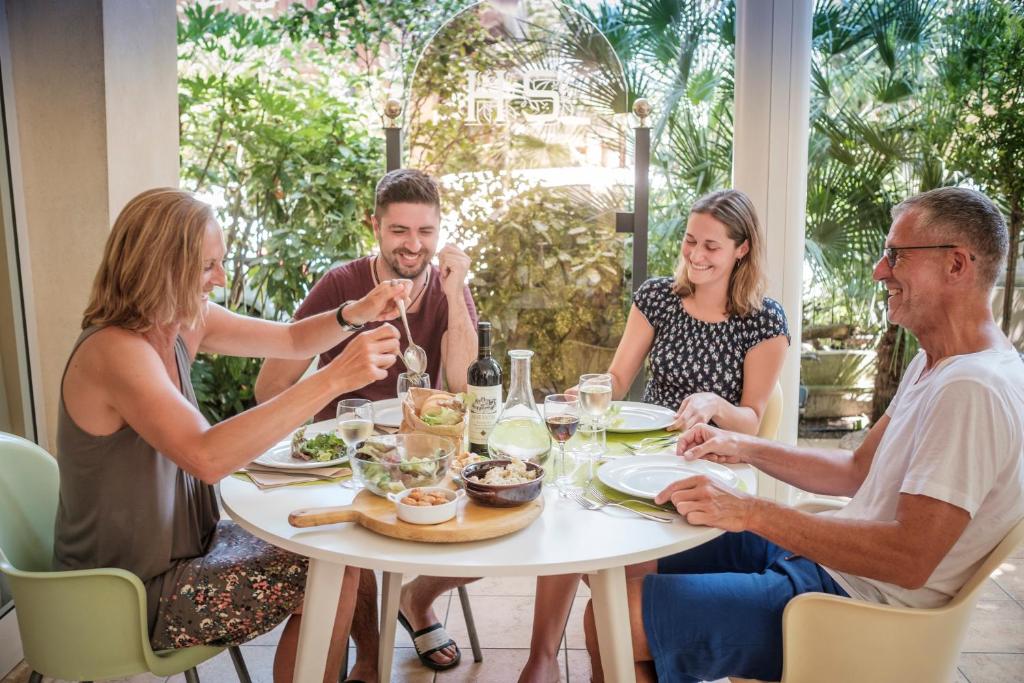 un grupo de personas sentadas alrededor de una mesa comiendo comida en Hotel Souvenir, en Bellaria-Igea Marina
