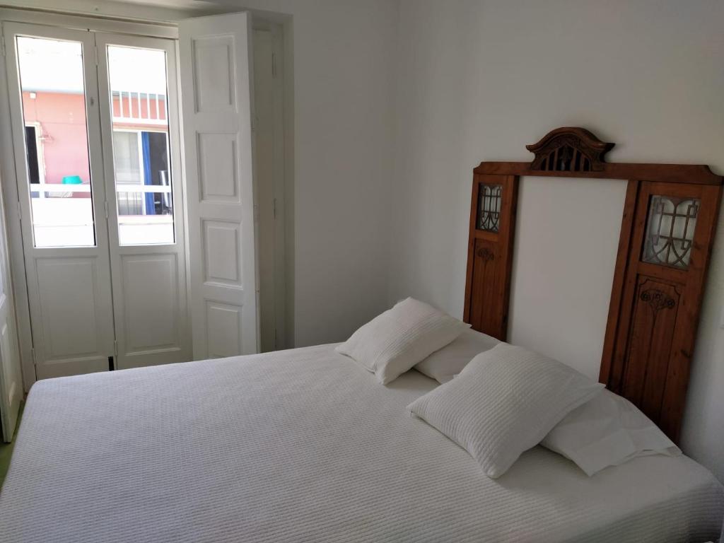 a white bed with two pillows in a bedroom at Urban Apartment in Faro