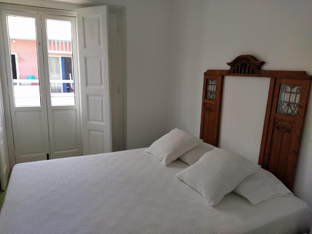 1 dormitorio con 1 cama blanca y 2 almohadas en Urban Apartment, en Faro