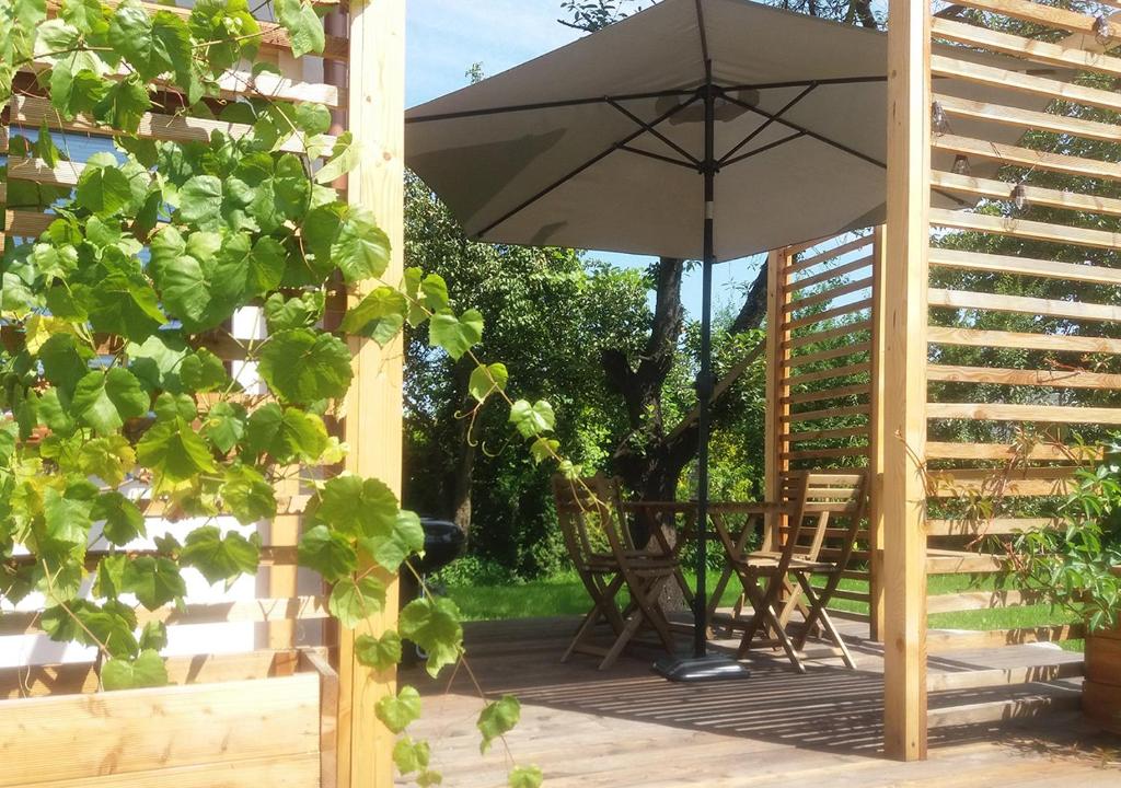 een patio met een parasol en een tafel en stoelen bij Apartamenty-Obok in Zator