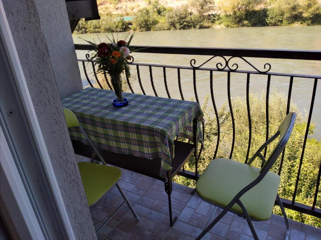 a table with a vase of flowers on a balcony at Vikendica pored Drine Foča in Handići