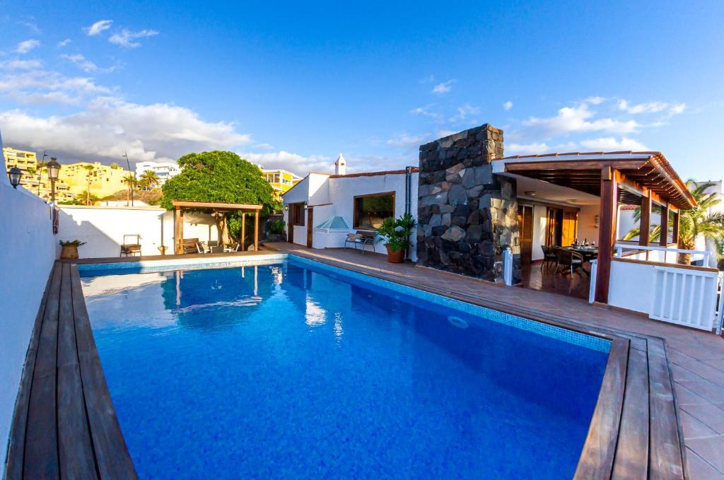 una piscina frente a una casa en Villa Punta Negra HEATED POOL tenerifesummervillas, en Puerto de Santiago