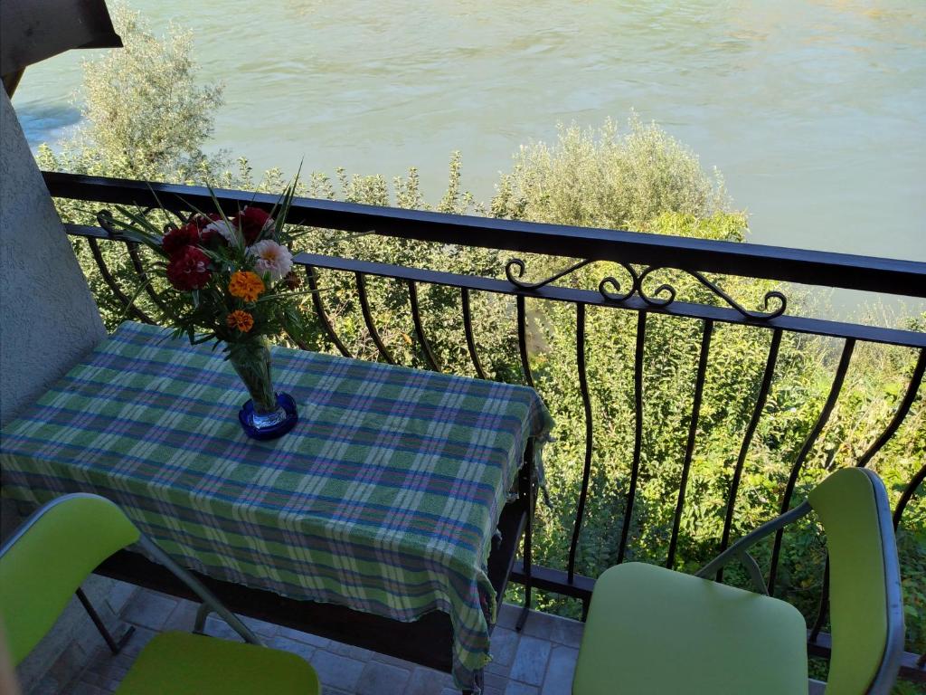 a table with a vase of flowers on a balcony at Vikendica pored Drine Foča in Handići